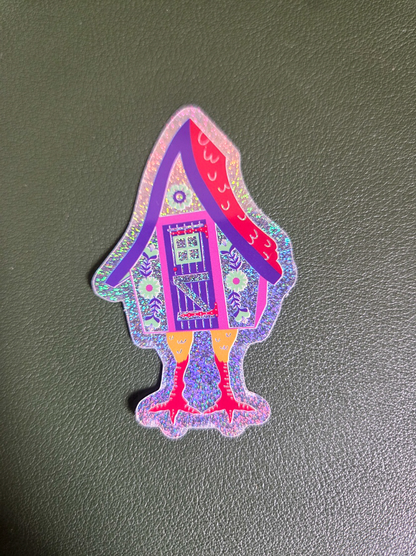 Sticker holographique pailleté de la maison de Baba Yaga sur pattes de poulet, toit violet et façade fleurie folk, Fortunae Studio